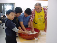 きつつきの菅原会長から直伝でそば粉をこねる子供達